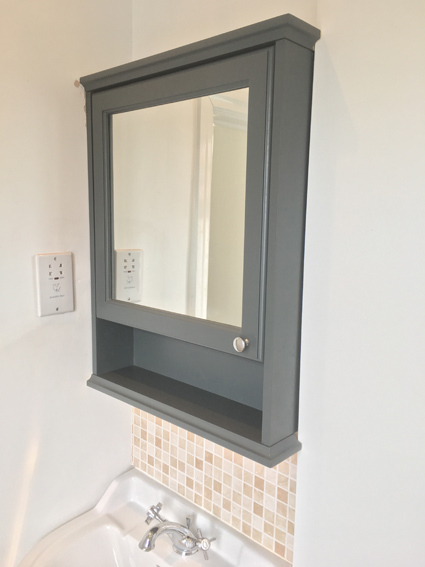 Dark blue bathroom cabinet cut to fit in alcove