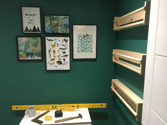 IKEA Flisat wall storage, picture shelves and photo gallery hung on a green painted wall with tools